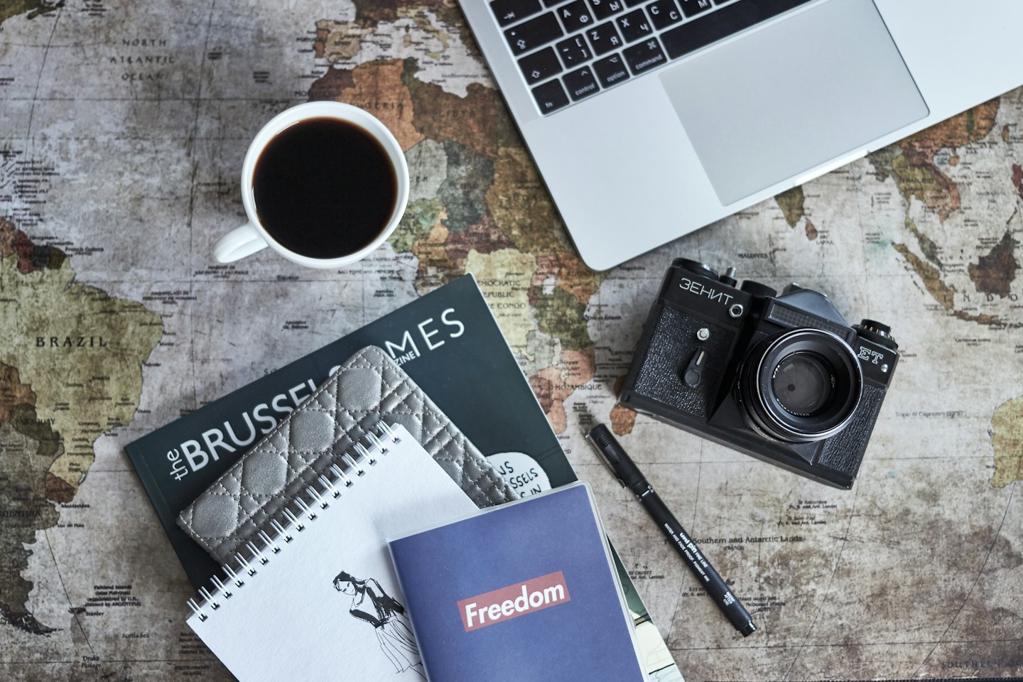 Travel planning essentials arranged on a vintage world map.