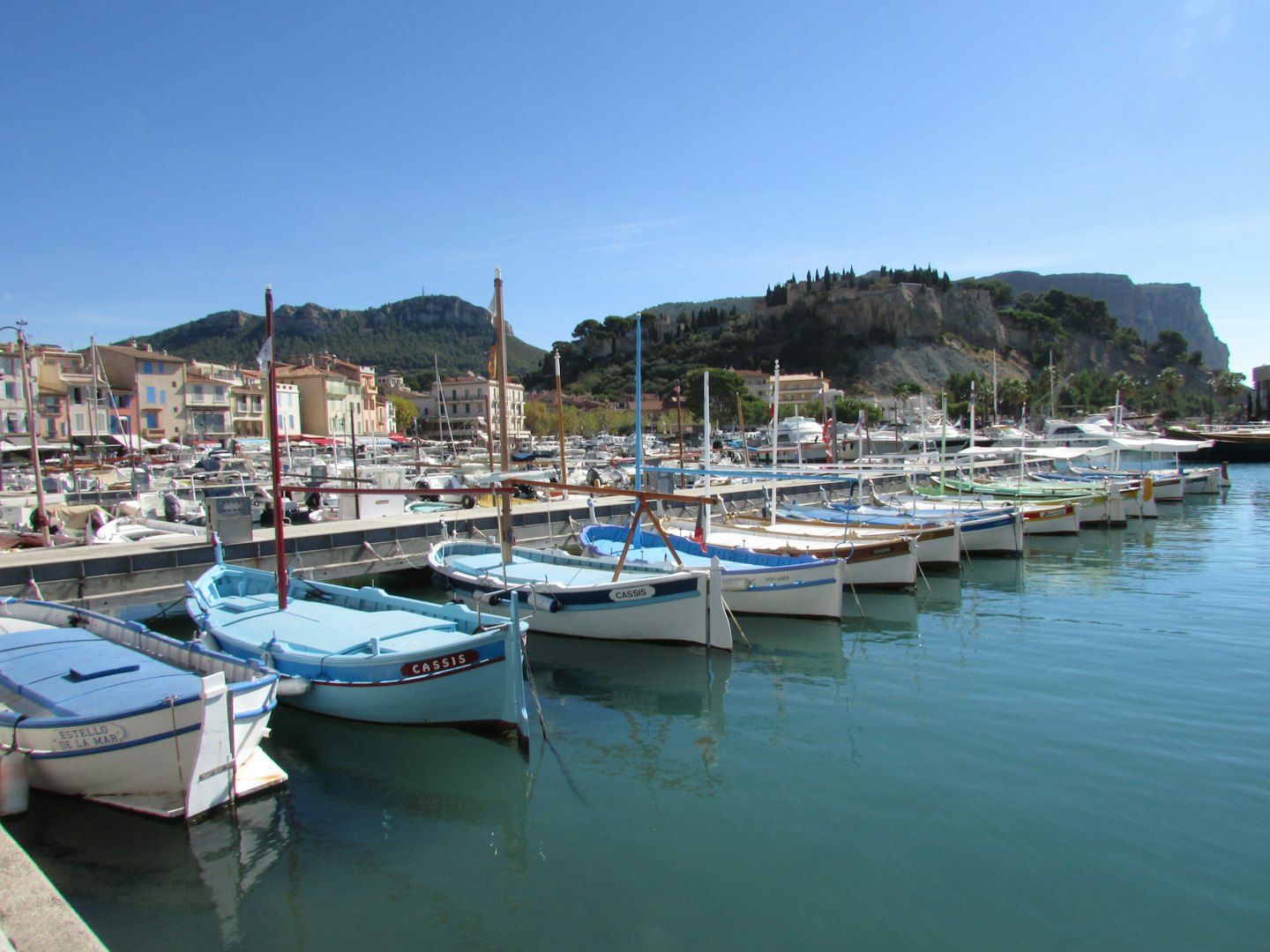 Colorful fishing boats and yachts in a Mediterranean harbor.