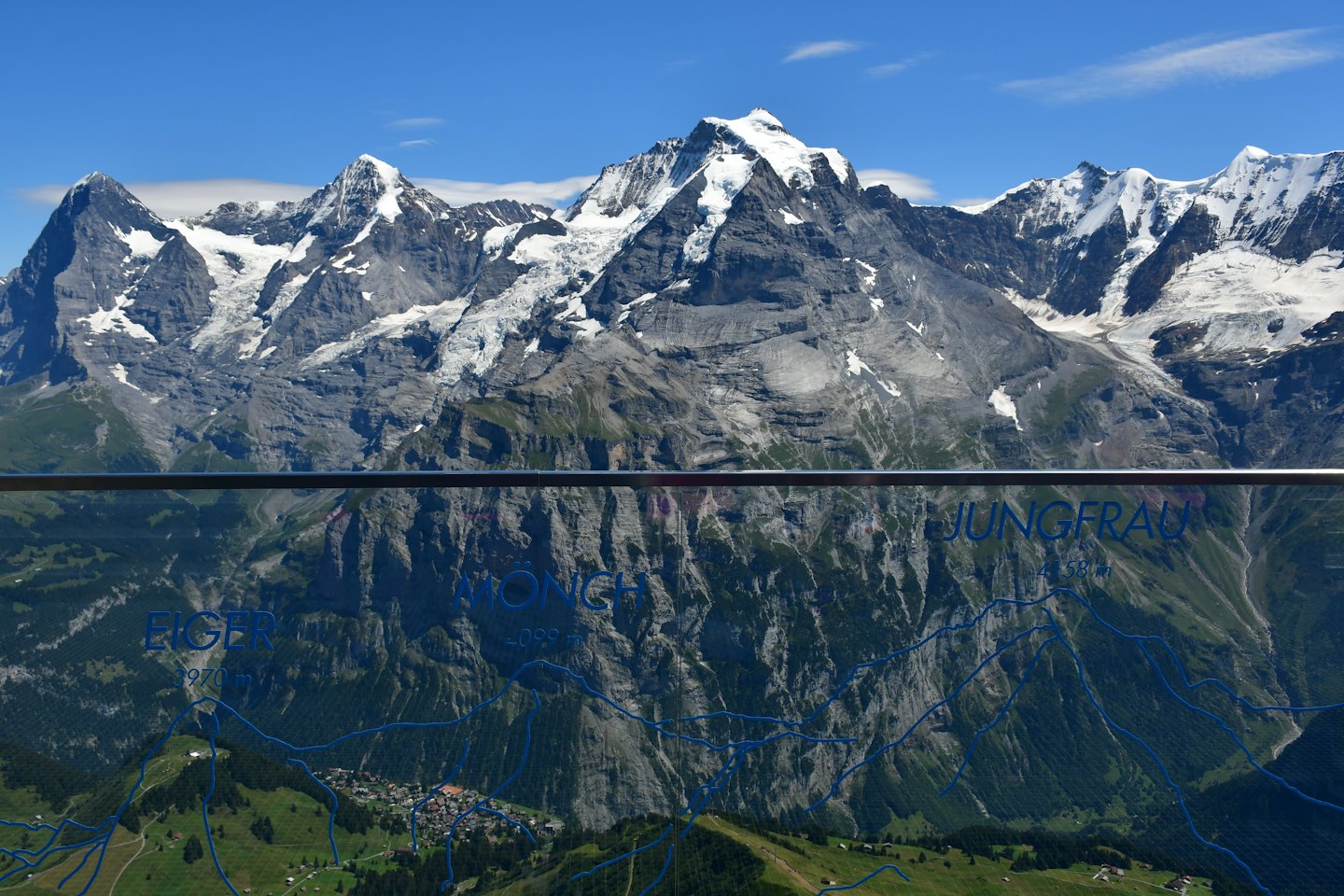 Snow-capped mountain range with a valley village and informational map overlay.
